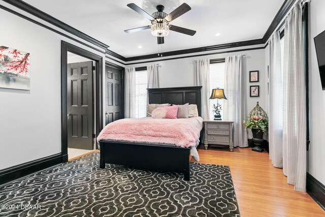 bedroom featuring hardwood / wood-style floors, ceiling fan, and crown molding