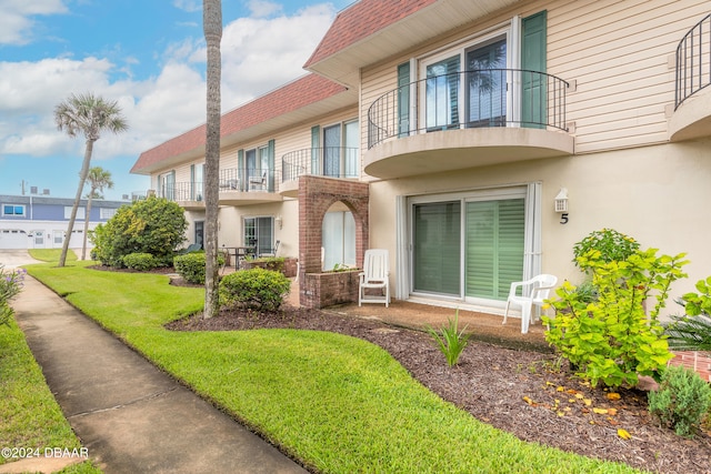 exterior space featuring a balcony and a front yard