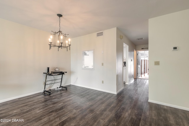 unfurnished dining area with dark hardwood / wood-style flooring and an inviting chandelier