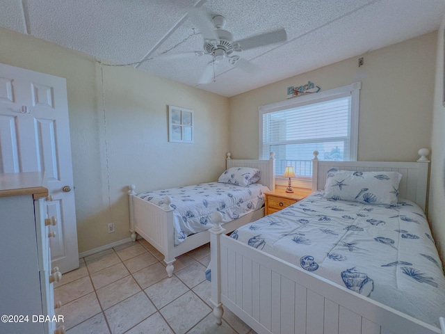 tiled bedroom featuring a textured ceiling and ceiling fan