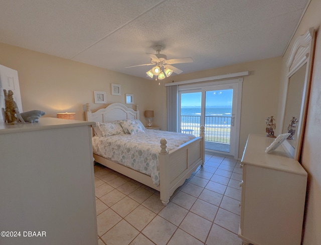 tiled bedroom with ceiling fan, a textured ceiling, a water view, and access to outside