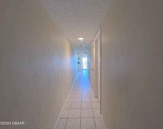 2700 Ocean Shore Blvd Unit 313, Ormond Beach, FL 32176 - corridor featuring a textured ceiling, light tile patterned floors, and arched walkways