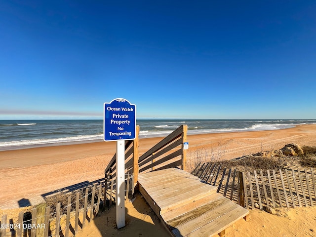 view of property's community featuring a beach view and a water view