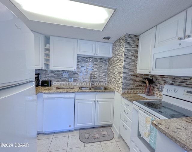 kitchen with white cabinets, sink, white appliances, and light stone countertops