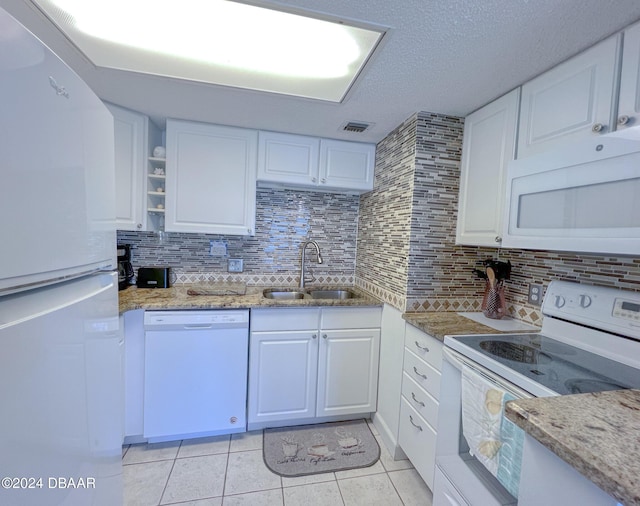 2700 Ocean Shore Blvd Unit 313, Ormond Beach, FL 32176 - kitchen featuring white appliances, light tile patterned floors, backsplash, and white cabinets