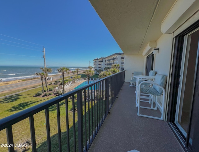 balcony featuring a beach view and a water view