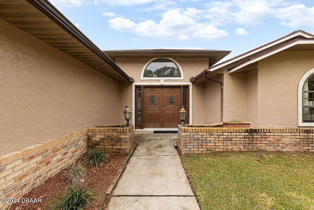 property entrance featuring a lawn