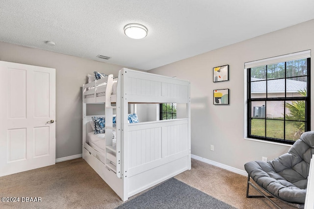 carpeted bedroom featuring multiple windows and a textured ceiling