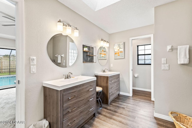 bathroom with vanity, a skylight, hardwood / wood-style floors, and a textured ceiling