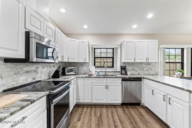 kitchen featuring dark wood-type flooring, appliances with stainless steel finishes, sink, and white cabinets