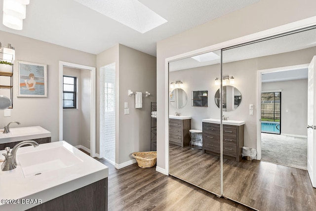 bathroom featuring hardwood / wood-style floors, vanity, and a skylight