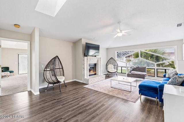 living room featuring a brick fireplace, ceiling fan, and dark hardwood / wood-style flooring