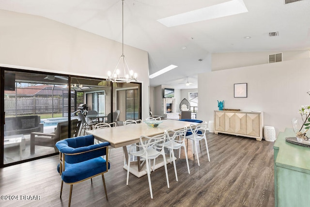 dining area with high vaulted ceiling, a skylight, wood-type flooring, and ceiling fan with notable chandelier