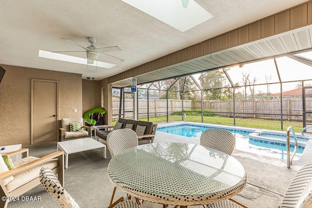 view of swimming pool featuring glass enclosure, outdoor lounge area, a patio, and ceiling fan