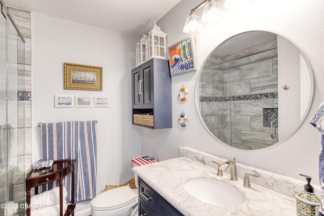 bathroom with vanity, an enclosed shower, a textured ceiling, and toilet