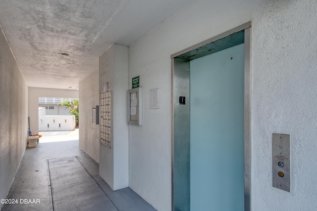 corridor with concrete floors and elevator