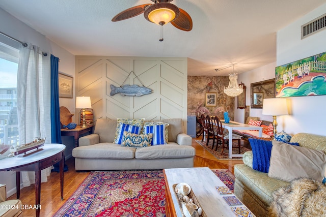 living room featuring hardwood / wood-style flooring and ceiling fan with notable chandelier