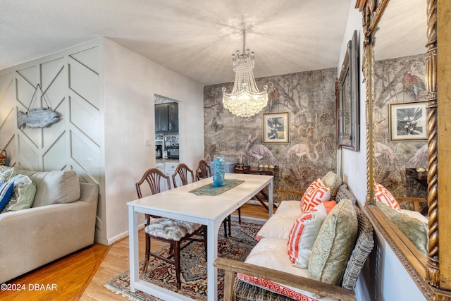 dining room with an inviting chandelier, hardwood / wood-style floors, and a textured ceiling