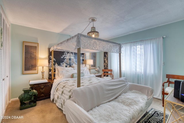 carpeted bedroom with a closet and a textured ceiling