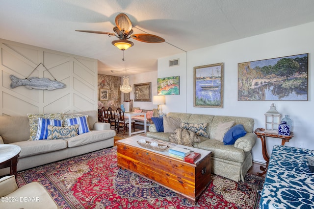 living room with ceiling fan and a textured ceiling