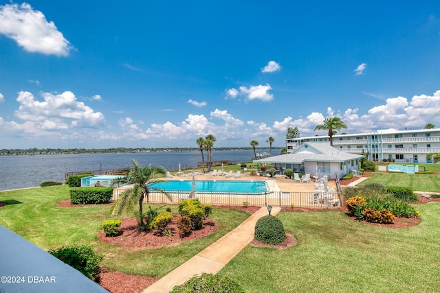 view of pool featuring a lawn, a patio, and a water view