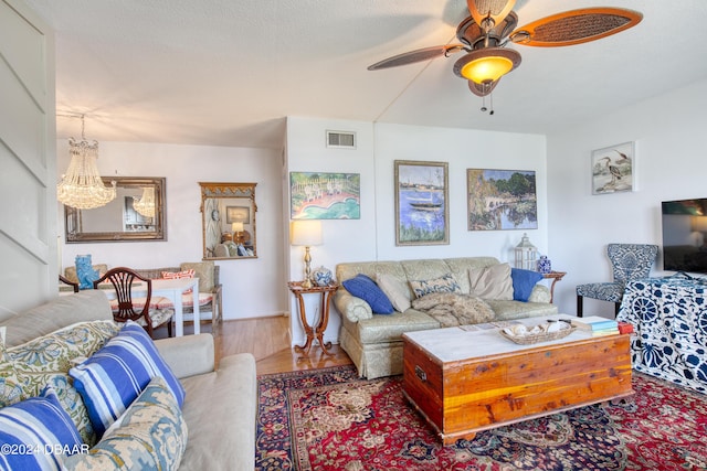 living room with ceiling fan, wood-type flooring, and a textured ceiling