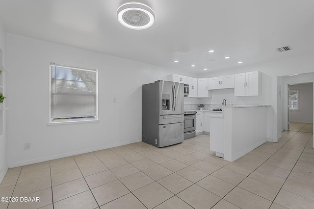 1214 Flomich St, Daytona Beach, FL 32117 - kitchen with stainless steel appliances, light tile patterned flooring, light countertops, recessed lighting, and white cabinetry