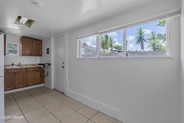 1214 Flomich St, Daytona Beach, FL 32117 - kitchen with light tile patterned flooring, light countertops, and plenty of natural light