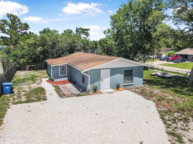 1214 Flomich St, Daytona Beach, FL 32117 - view of front of property featuring gravel driveway, a fenced backyard, and roof with shingles