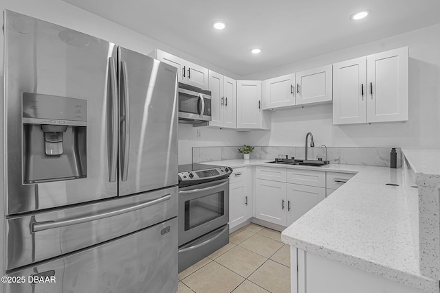1214 Flomich St, Daytona Beach, FL 32117 - kitchen with stainless steel appliances, white cabinetry, light stone counters, and recessed lighting