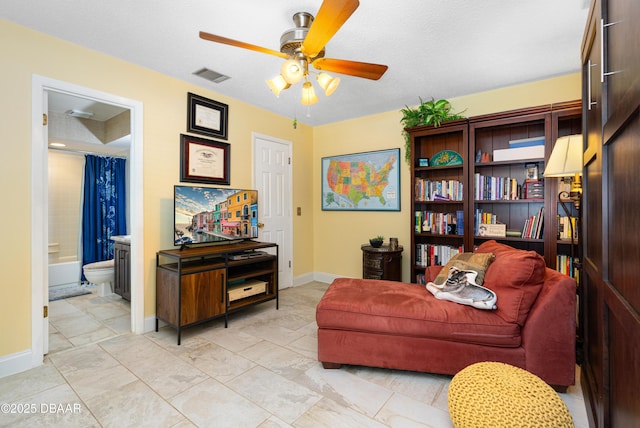 living area with a ceiling fan, baseboards, and visible vents