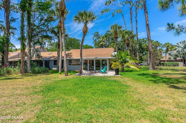 rear view of house with a lawn and a patio