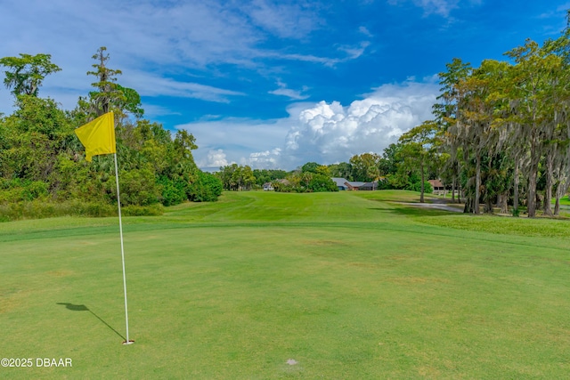view of property's community with a lawn and view of golf course