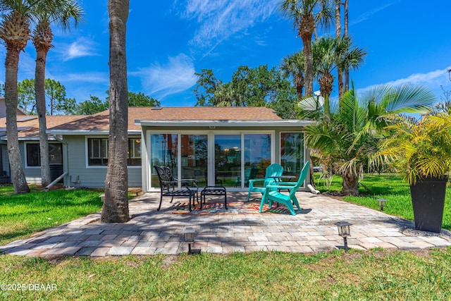 rear view of house with a patio and a lawn
