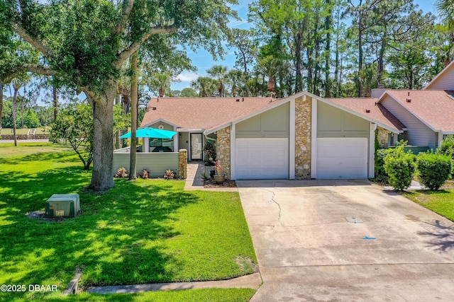 ranch-style home featuring driveway, a front yard, a garage, a shingled roof, and stone siding
