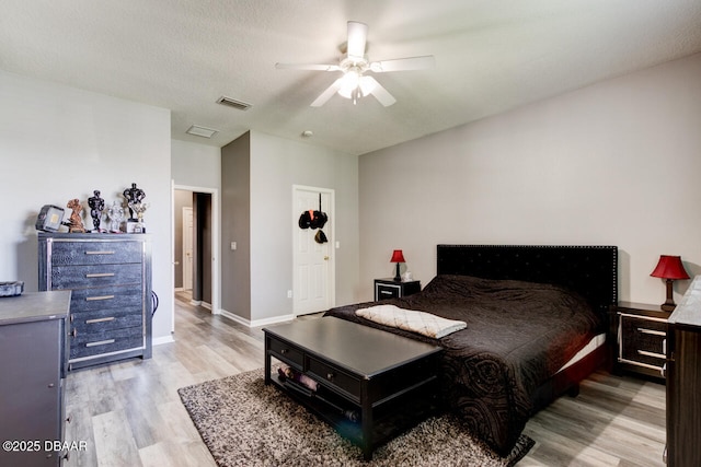 bedroom with ceiling fan, a textured ceiling, and light wood-type flooring