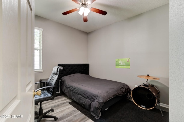 bedroom with multiple windows, a textured ceiling, light hardwood / wood-style flooring, and ceiling fan