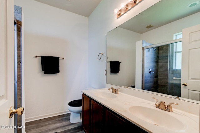 bathroom featuring walk in shower, vanity, wood-type flooring, and toilet