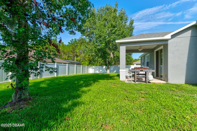 view of yard with ceiling fan and a patio