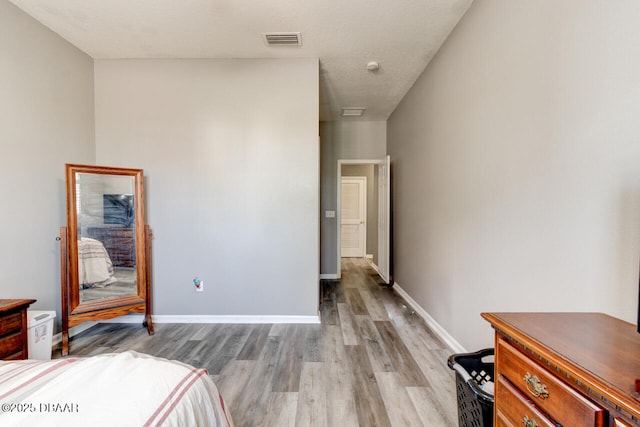 bedroom with light hardwood / wood-style floors and a textured ceiling