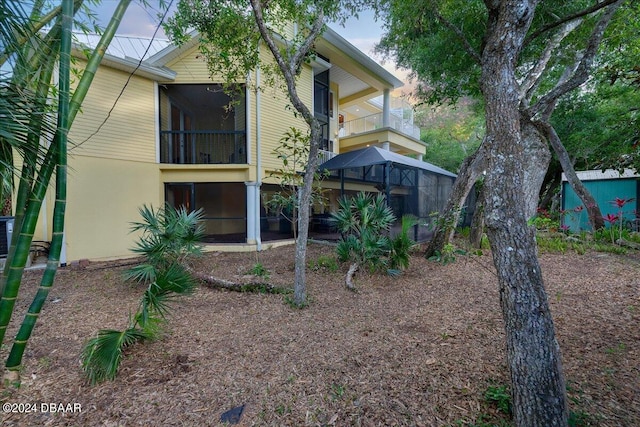 back of property featuring a balcony and a sunroom