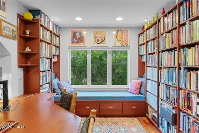 unfurnished room featuring light wood-type flooring and a textured ceiling