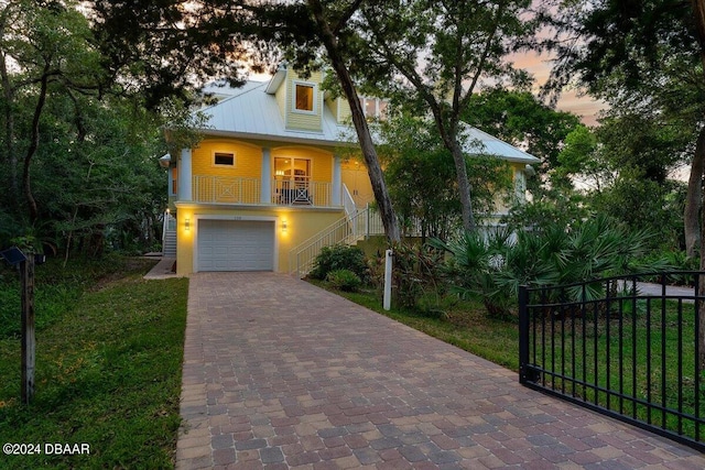 view of front of house featuring a lawn, a garage, and covered porch