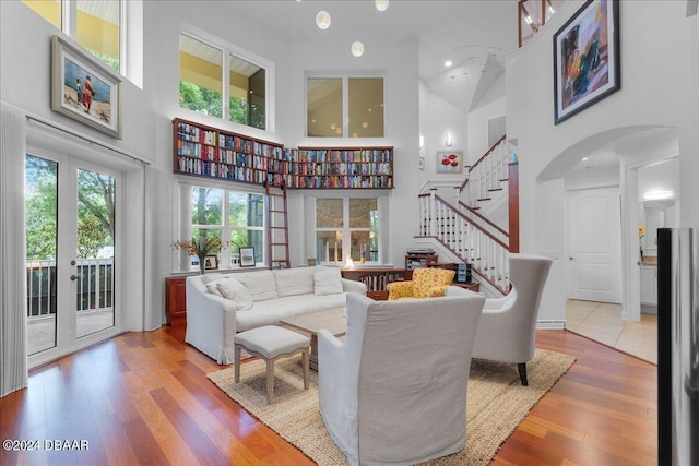 living room with a towering ceiling and hardwood / wood-style flooring