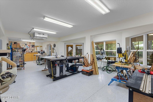 misc room featuring a workshop area, french doors, and a textured ceiling