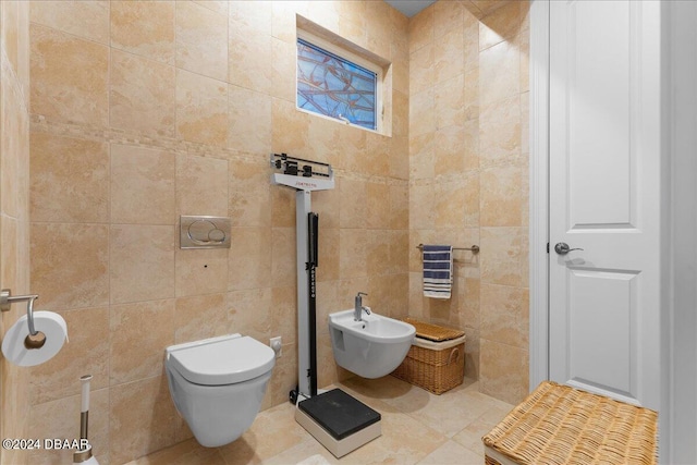 bathroom with tile walls, a bidet, tile patterned floors, and toilet