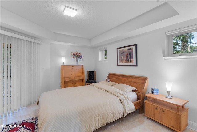 bedroom with multiple windows and a textured ceiling