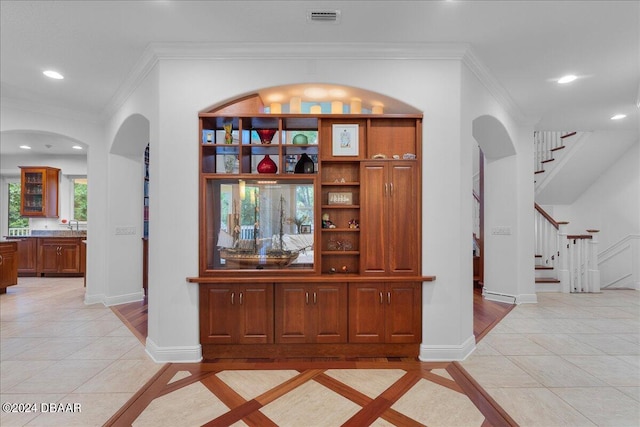 interior space with light tile patterned floors and ornamental molding