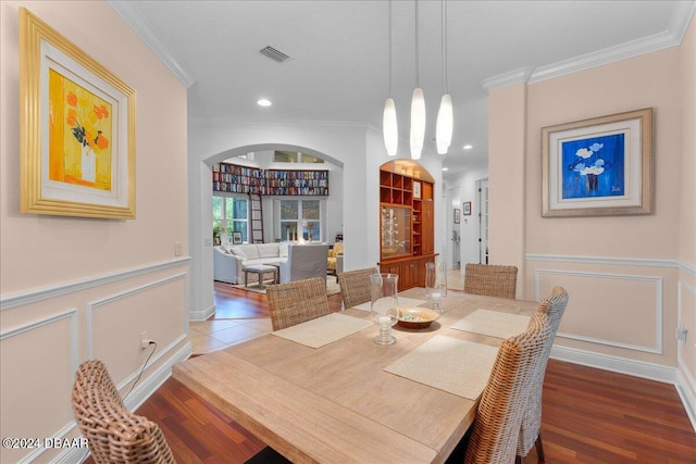 dining area with dark wood-type flooring, built in features, and ornamental molding