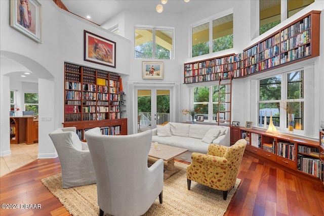 sitting room featuring a high ceiling, wood-type flooring, and plenty of natural light